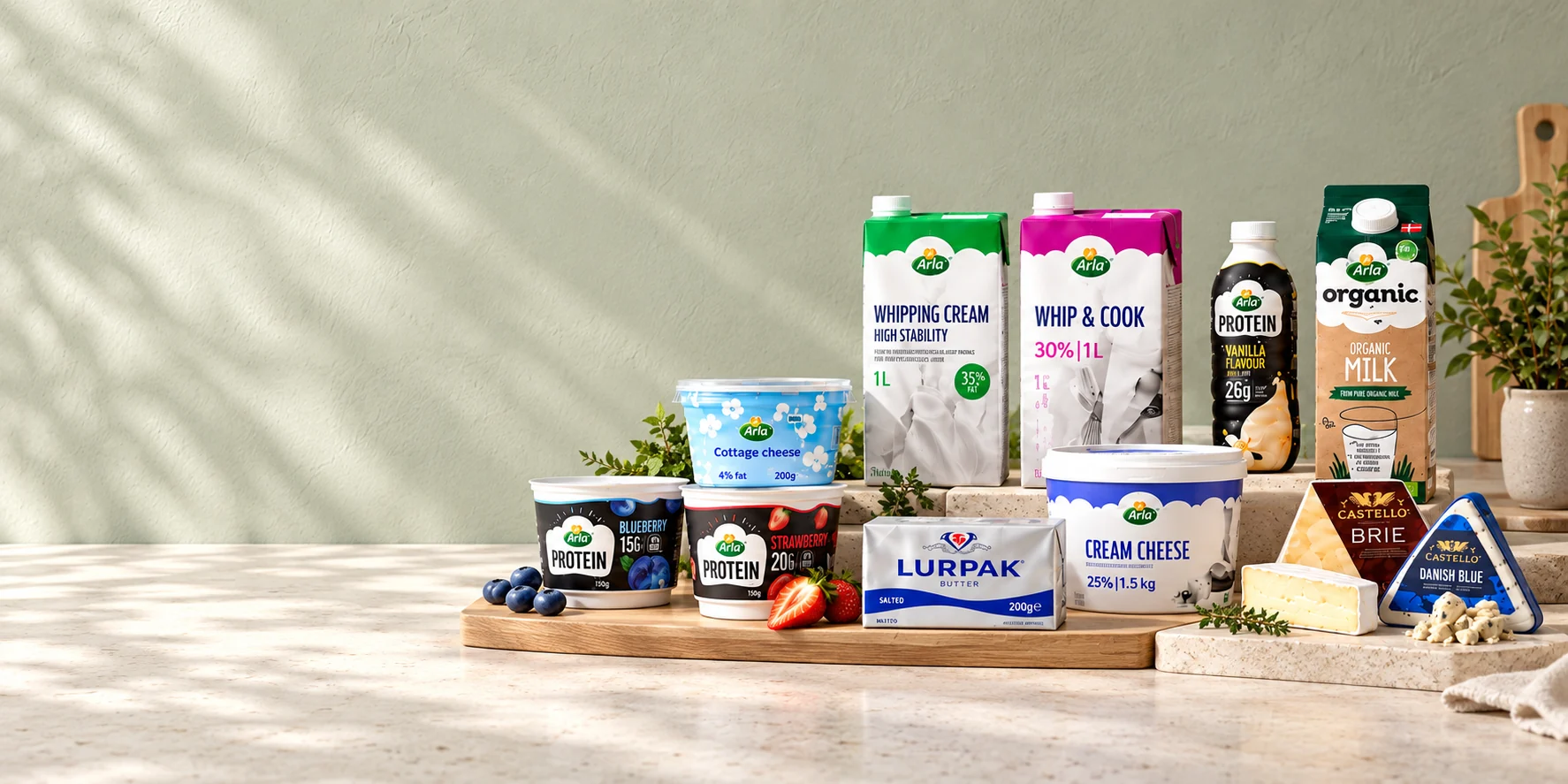 The Arla, Lurpak and Castello range on a kitchen counter: protein yoghurts, cottage cheese, whipping cream, Whip and Cook, organic milk, Lurpak butter, cream cheese, brie and Danish blue