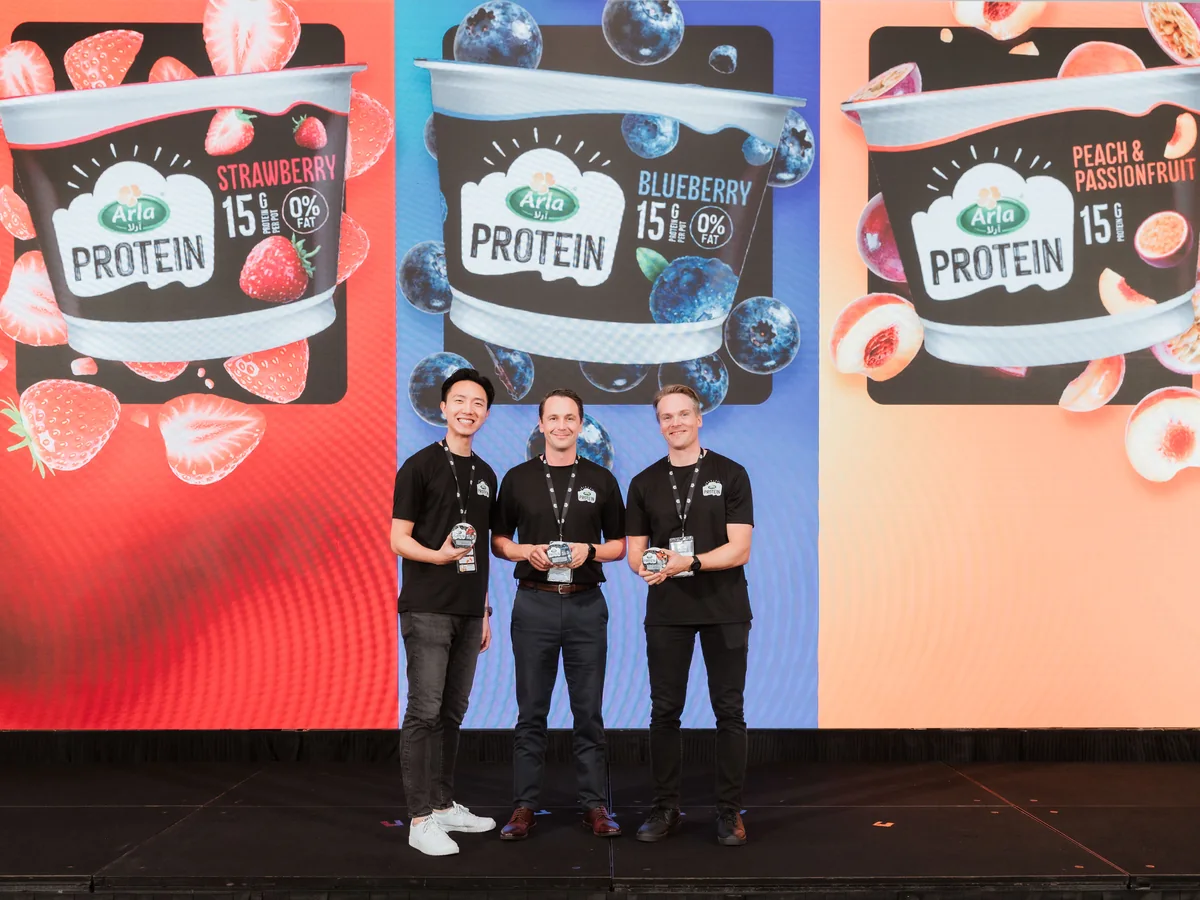 Arla presenters holding the three Arla Protein flavours on stage at the Singapore launch