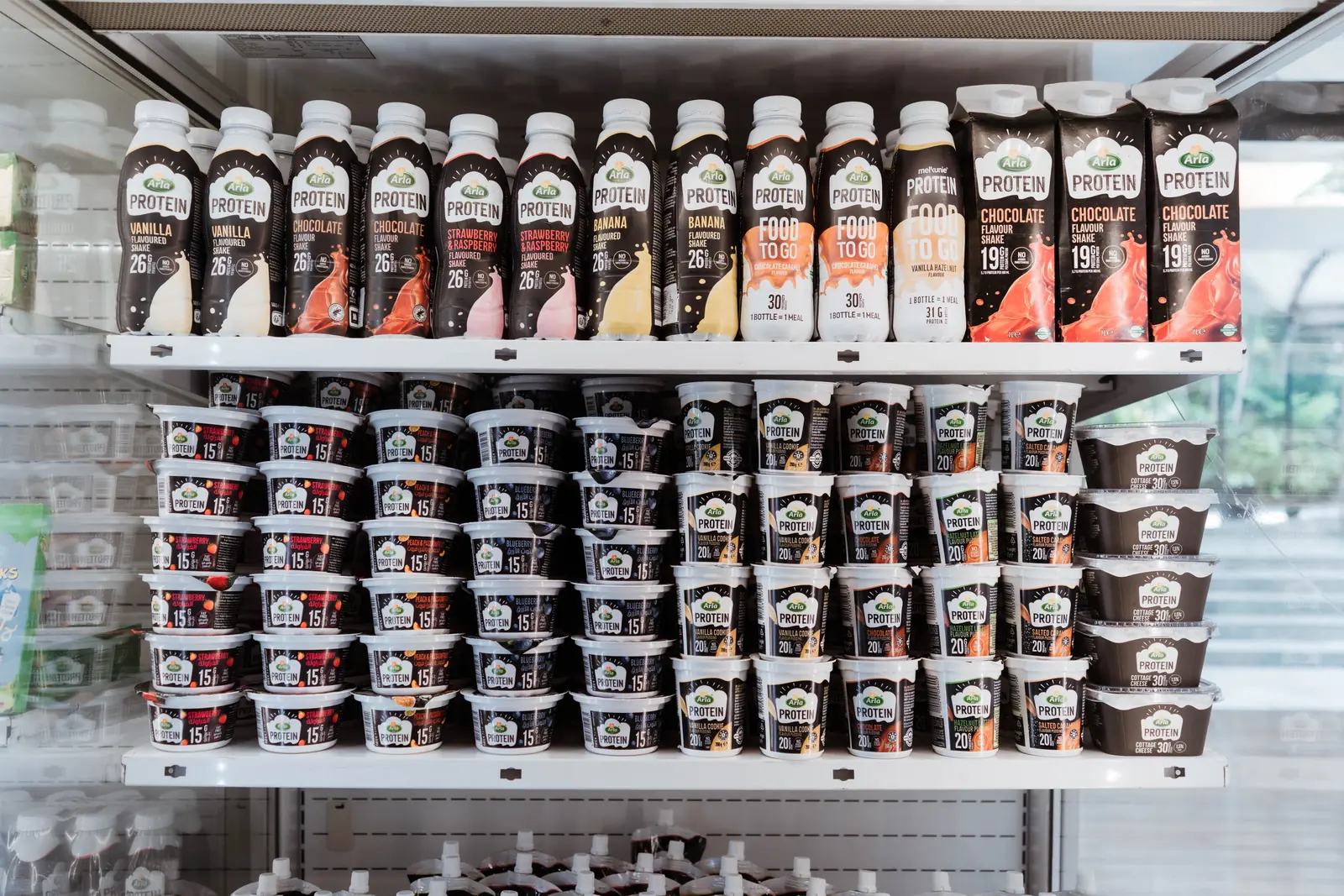 Arla Protein yoghurts, puddings, shakes and cottage cheese on display in a chiller