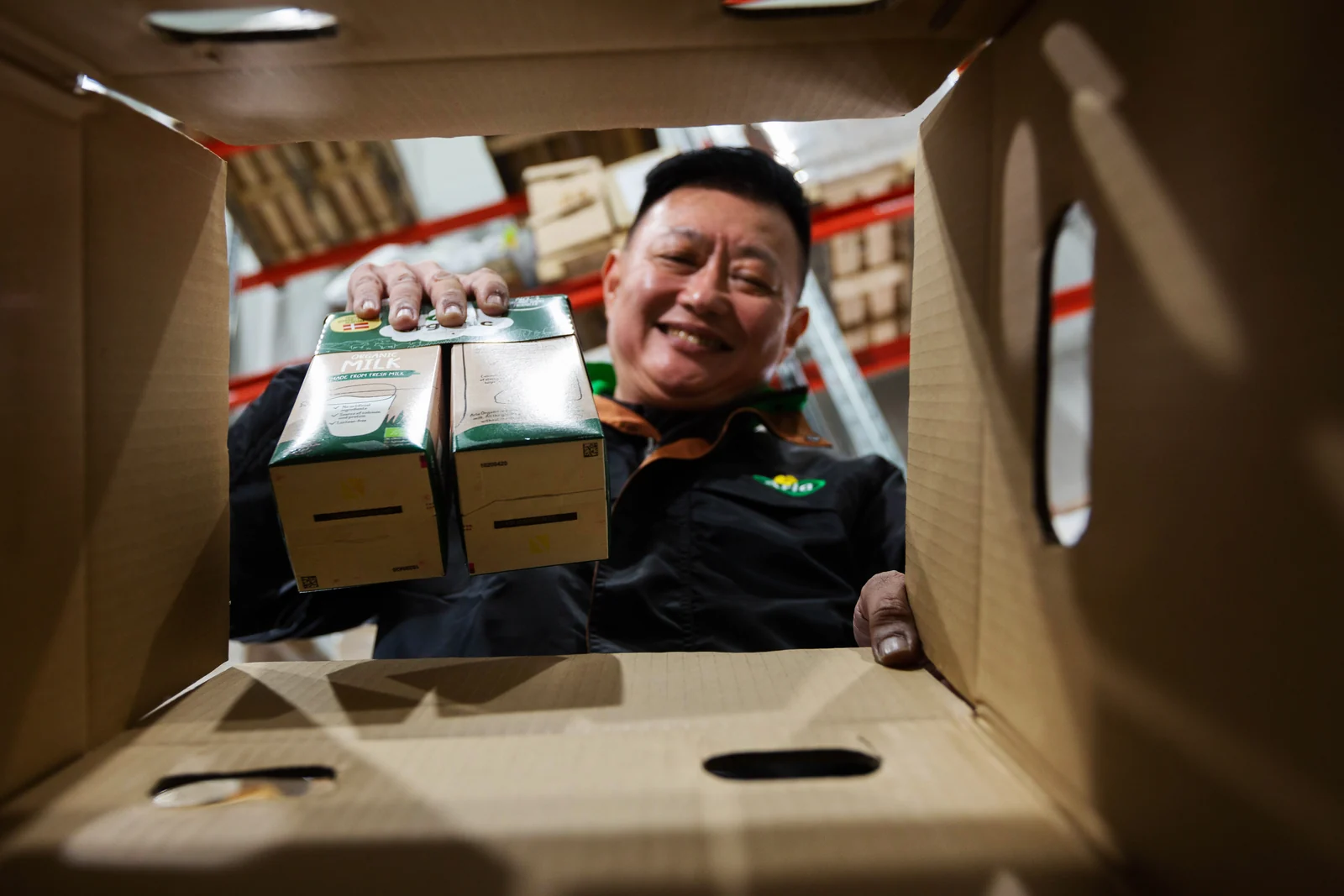 A Trade-Pro picker passing Arla organic milk into a delivery carton at the Tuas facility